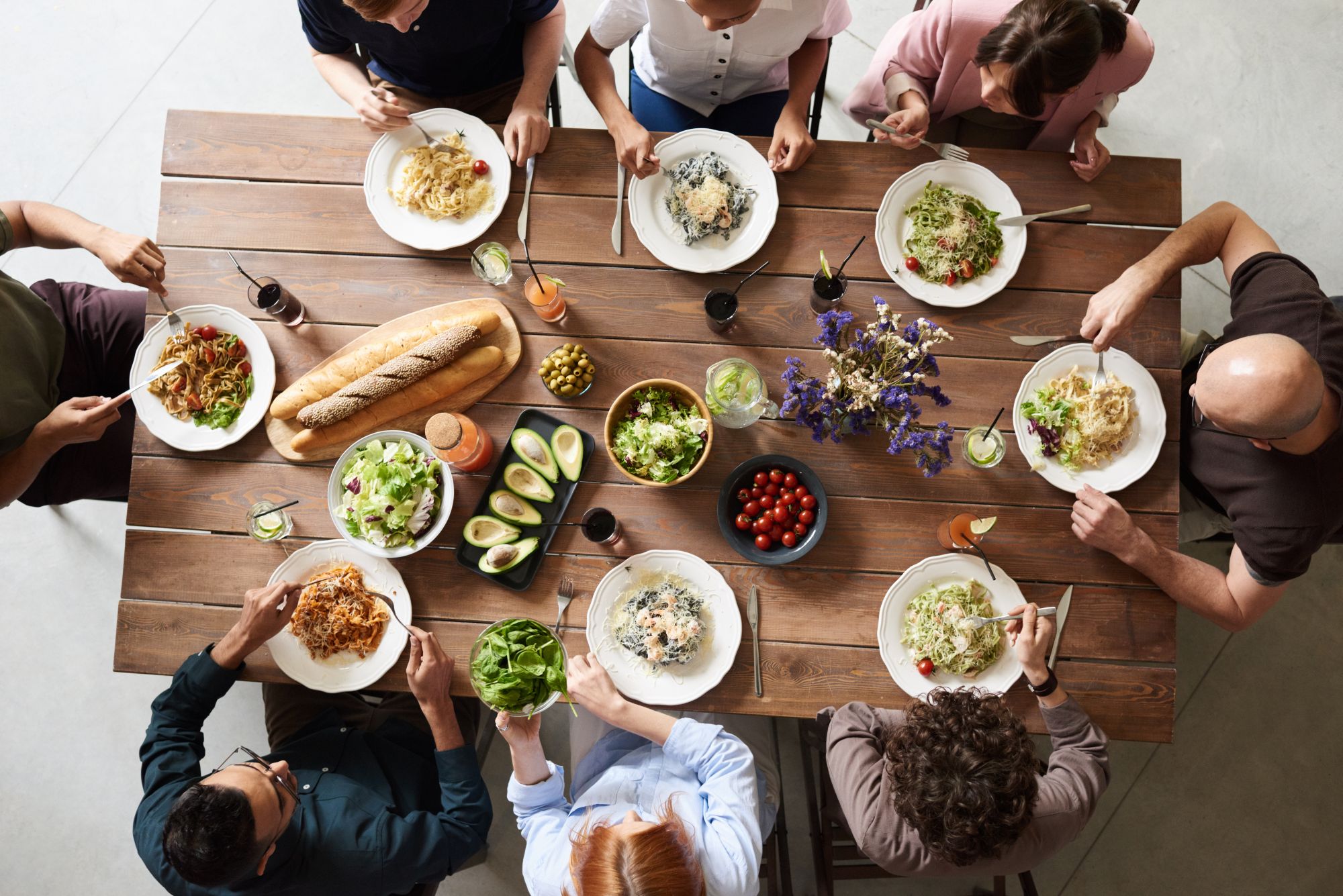 Blick von oben auf eine Gruppe von Menschen sitzt gemeinsam an einem Tisch und isst.